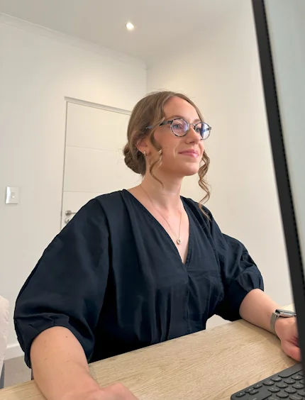 Sam The GC founder working at a computer smiling.